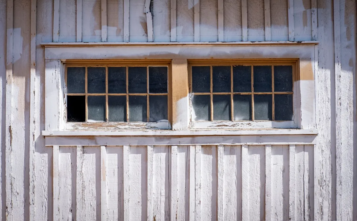 Verwittertes altes Holzfenster mit Sprossen und beschädigten Scheiben