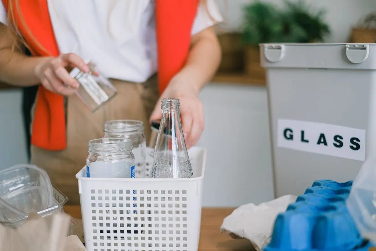 Glas wird getrennt in einen Sammelbehälter für Altglas sortiert